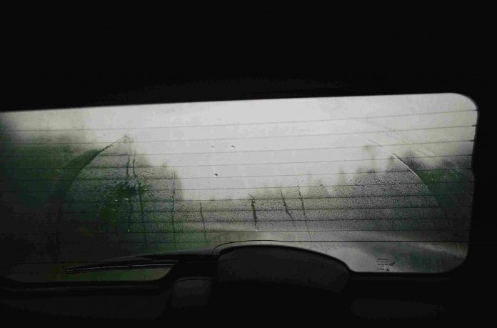 The rear window of a car covered in mist.