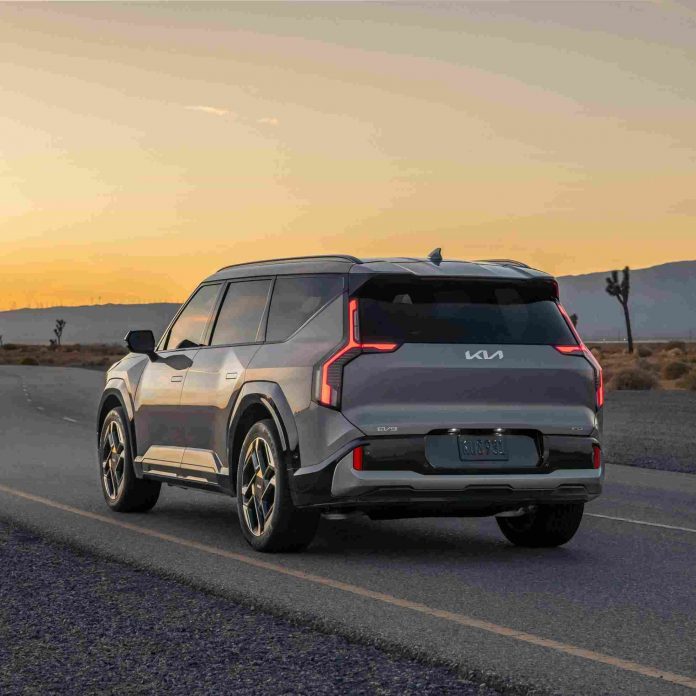 A gray SUV driving along a desert highway at dusk.